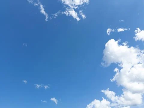 Blue sky with fluffy white clouds. A serene and peaceful image perfect for .. Stock Photos