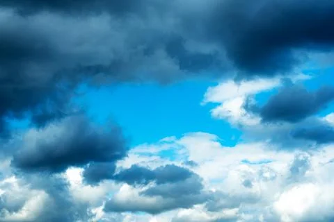 Blue sky with a frame of dark clouds and white clouds Stock Photos