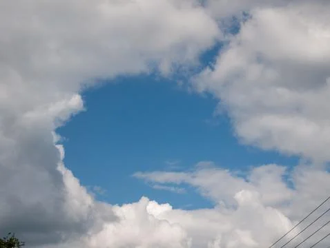Blue sky framed by dramatic clouds Foto stock