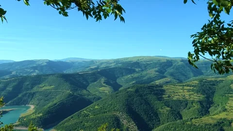 Blue sky frames green hills and valleys below. Kozji Kamen viewpoint, Serbia Видео 342341004