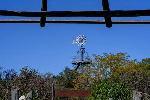 Blue sky frames a rustic windmill 库存照片