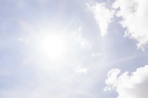 Blue sky framing white fluffy cumulus clouds on sunny day Stockfoto's