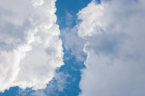 Blue sky in gap between heavy cumulus clouds, clearing up of weather Stock Photos