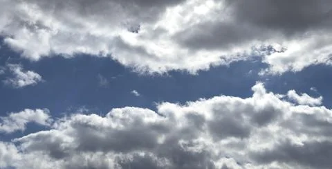 **Blue sky gap between layers of white and grey clouds, wide panoramic Photos