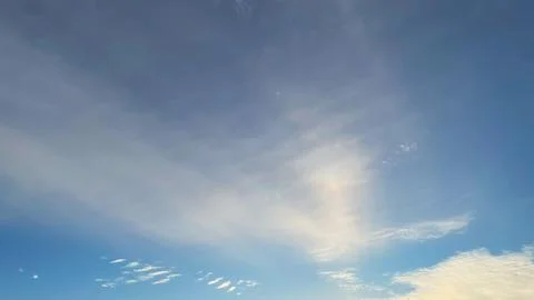 Blue sky with a gradient of light and soft, streaky white clouds. Serene an.. Stock Photos