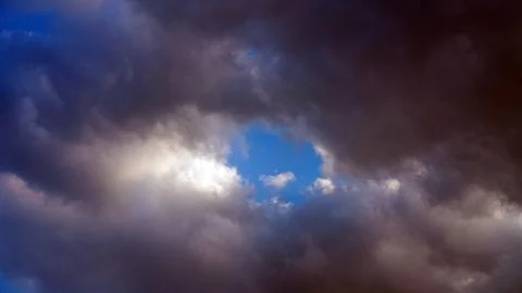 Blue Sky Hole Breaking Through Dark Storm Clouds Stock Photos