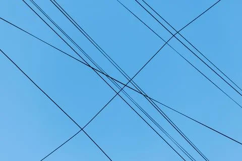 Blue sky with intersecting power lines Stock Photos
