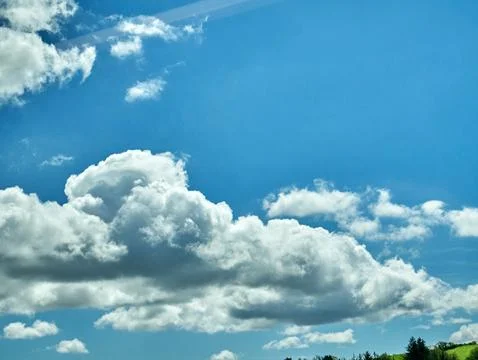 Blue sky with large white clouds over landscape Фото