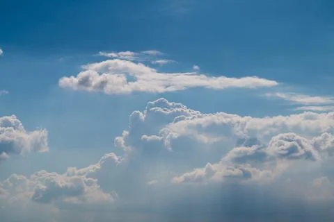 Blue sky with layered white clouds and sun rays Stock Photos