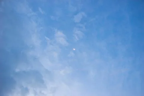 Blue sky with light clouds and moon. Beautiful sky. Scenic view in evening Stock Photos