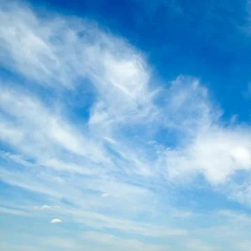 Blue sky with light feathery clouds. Stock Photos