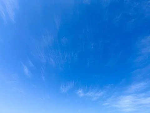 Blue sky with light soft wispy cirrus clouds on a bright sunny day background Stock-Fotos