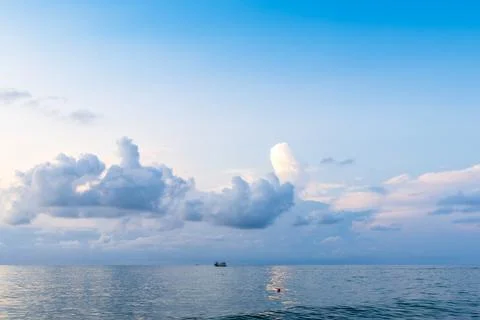 Blue sky with low clouds in over sea water at dusk Stock Photos