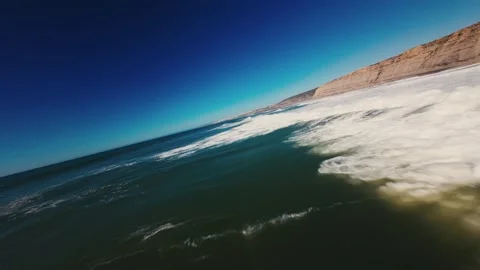 Blue sky meets crashing waves near rugged cliffs Video stock 339803581