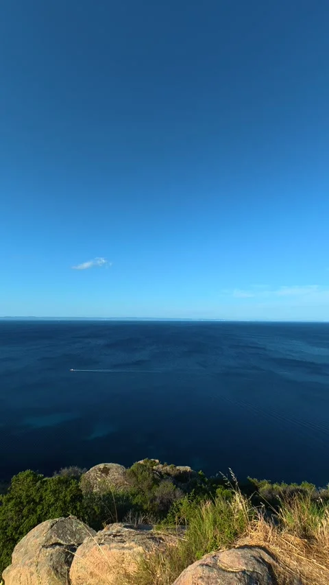 Blue sky meets deep ocean in serene coastal vista. Lagomandra, Greece. Vertical Stock Footage 339624141
