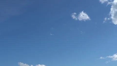 Blue sky with metamorphic white clouds that move and dissolve on fly. Time Lapse Stock Footage 106866820