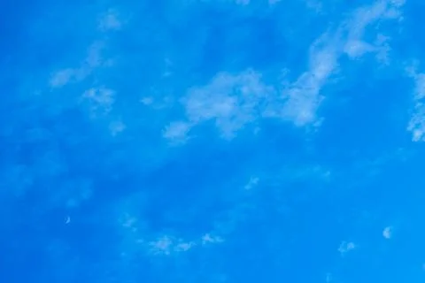 Blue sky with the Moon down left corner. Stock Photos