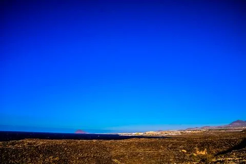 A blue sky with a mountain in the background Stock Photos