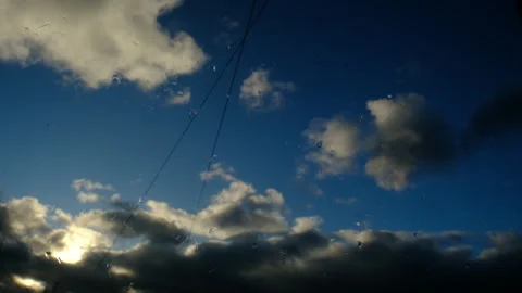 Blue sky, moving Time lapse white clouds. Water drops of rain on glass Video stock 304300041