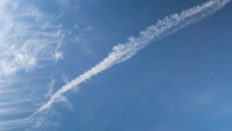 The blue sky moving white clouds in a bizarre shape and the trail of an airplane Video stock 180416822