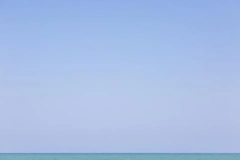 A blue sky with no clouds over the thin turquoise sea line Stock Photos