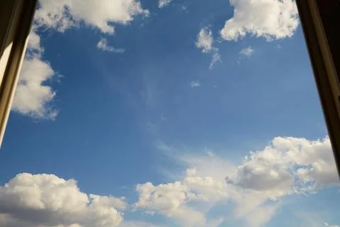 Blue sky in open window with white clouds Stock Photos