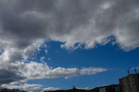 Blue sky opening through dramatic shifting clouds Foto stock