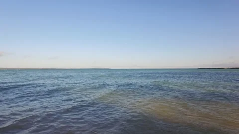 Blue sky over slightly moving waves Stock Footage 158976941