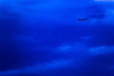 A blue sky with a plane flying through it Stock Photos