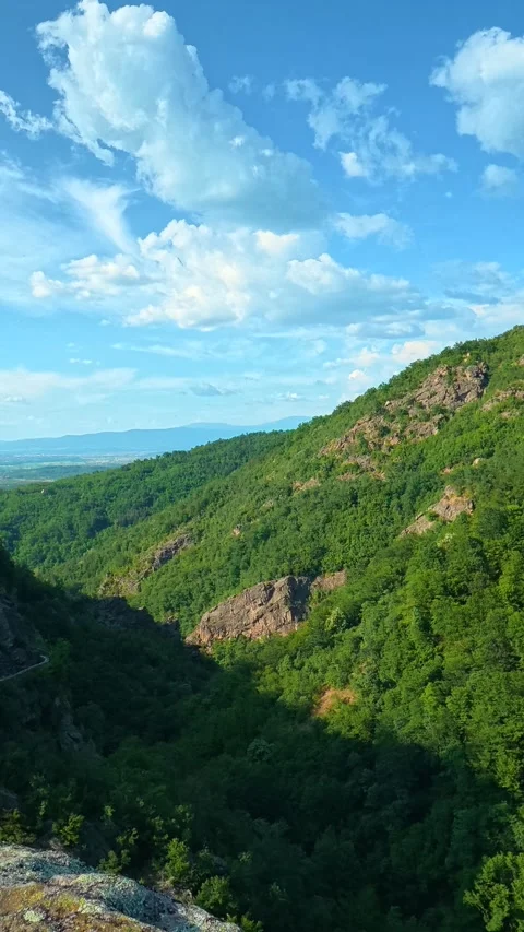 Blue sky with puffy clouds frames the view. Sokolica rock, Serbia. Vertical Stock Footage 341132317