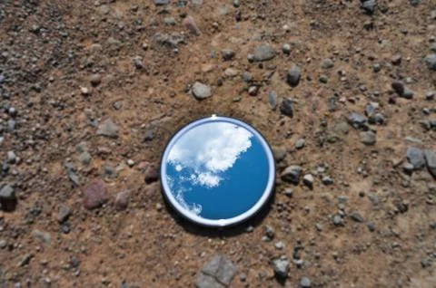Blue sky reflected in the mirror breaking up on dry soils. Climate change c.. Stock Photos