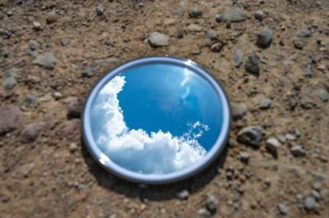 Blue sky reflected in the mirror breaking up on dry soils. Climate change con Stock Photos