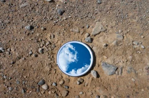 Blue sky reflected in the mirror breaking up on dry soils. Climate change c.. Stock Photos