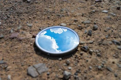 Blue sky reflected in the mirror breaking up on dry soils. Climate change c.. Stock Photos