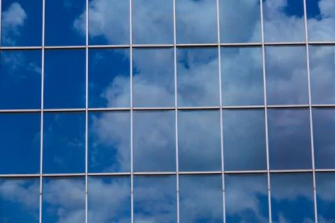 Blue sky reflected in modern building mirror glass wall Stock Photos