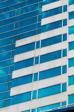 Blue sky reflected in modern building mirror glass wall Stock Photos