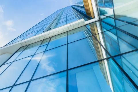 The blue sky is reflected in the windows of a modern office building Stock Photos