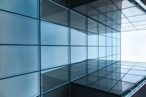 The blue sky is reflected in the windows of a modern office building Stock Photos