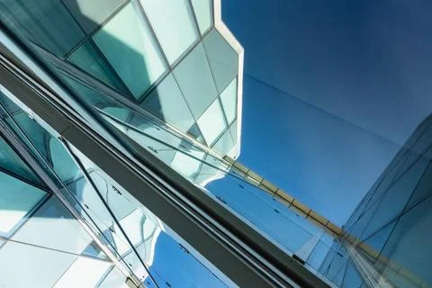 The blue sky is reflected in the windows of a modern office building Stock Photos