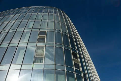 The blue sky is reflected in the windows of a modern office building Stock Photos