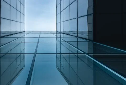 The blue sky is reflected in the windows of a modern office building Stock Photos
