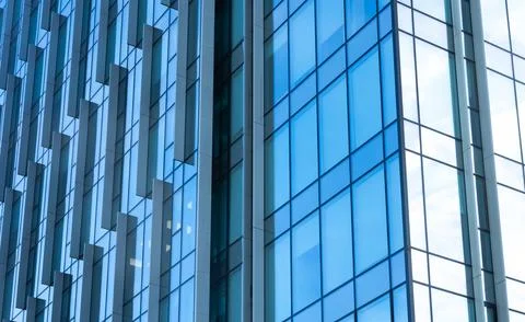 The blue sky is reflected in the windows of a modern office building Stock Photos
