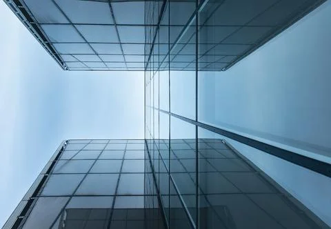 The blue sky is reflected in the windows of a modern office building Stock Photos