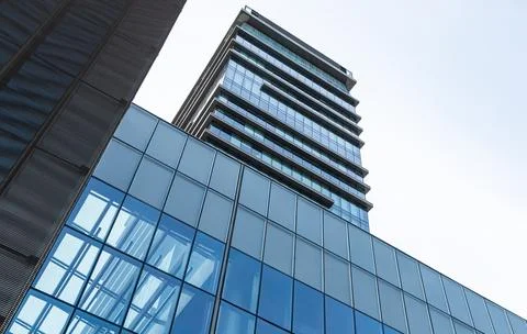 The blue sky is reflected in the windows of a modern office building Stock Photos
