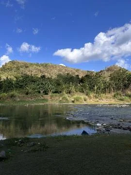 Blue sky reflects in calm river waters Stockfoto's