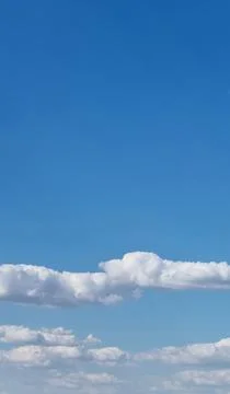 Blue sky with scattered white clouds. Natural sky background Stock Photos