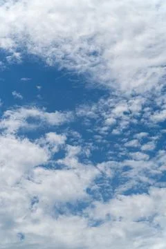 Blue sky with scattered white clouds background Stock Photos