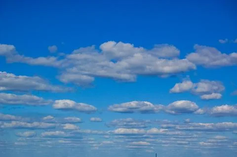 Blue sky with scattered white clouds in a summer day Stock Photos