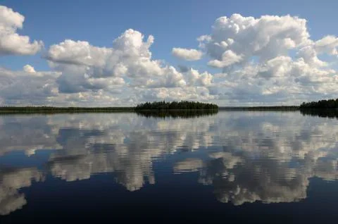 Blue sky, small clouds and a distant island Stock Photos