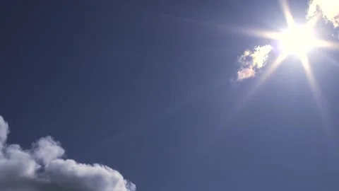 Blue sky with small clouds, sun, sunbeams, birds - sky background - Real Time Stock Footage 154255171